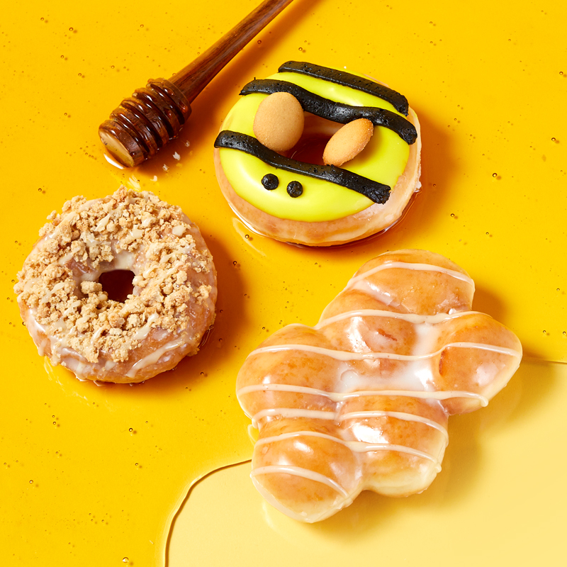 commercial food photograph of Krispy Kreme honey doughnuts on bed of yellow honey styled and shot by food stylists and photographers at Salt Paper Studio