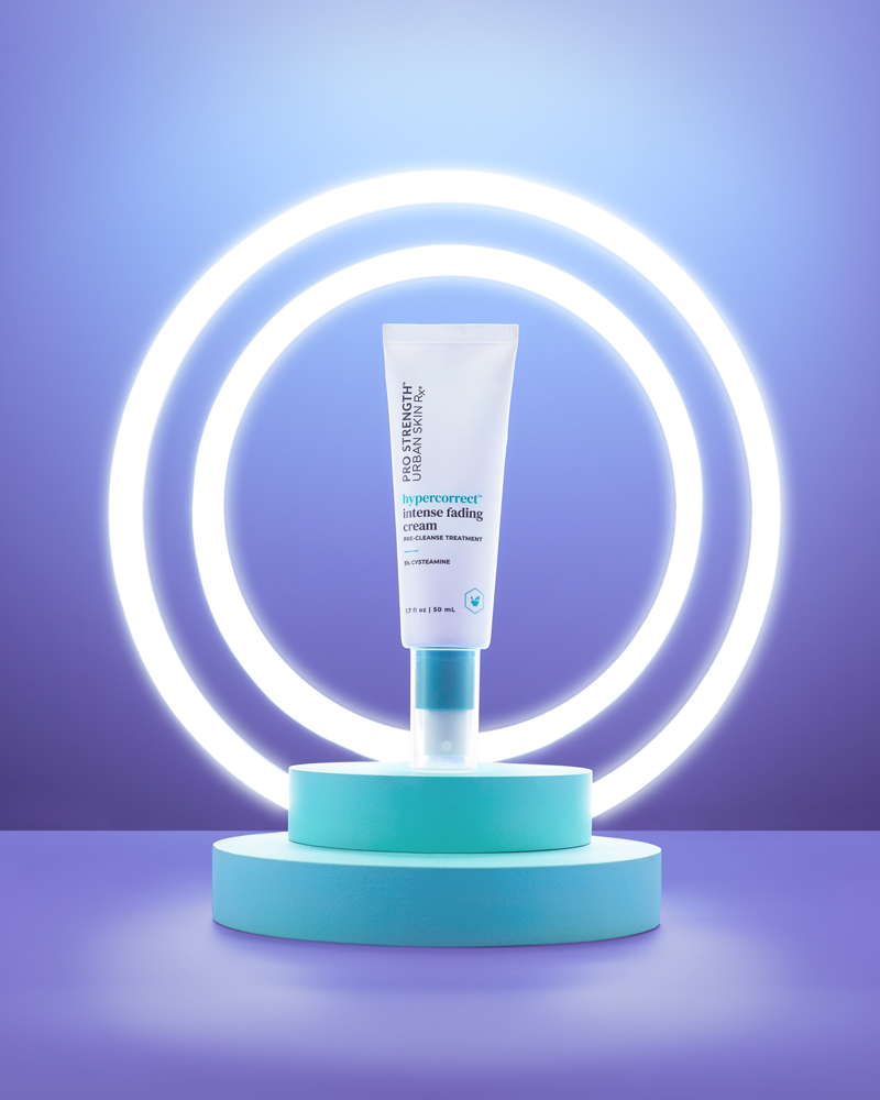 commercial product photography of skincare bottle in two ring lights on purple background and teal risers for amazon and website