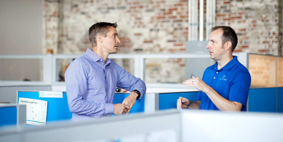 Lifestyle photography to two male colleagues having a discussion in an open office