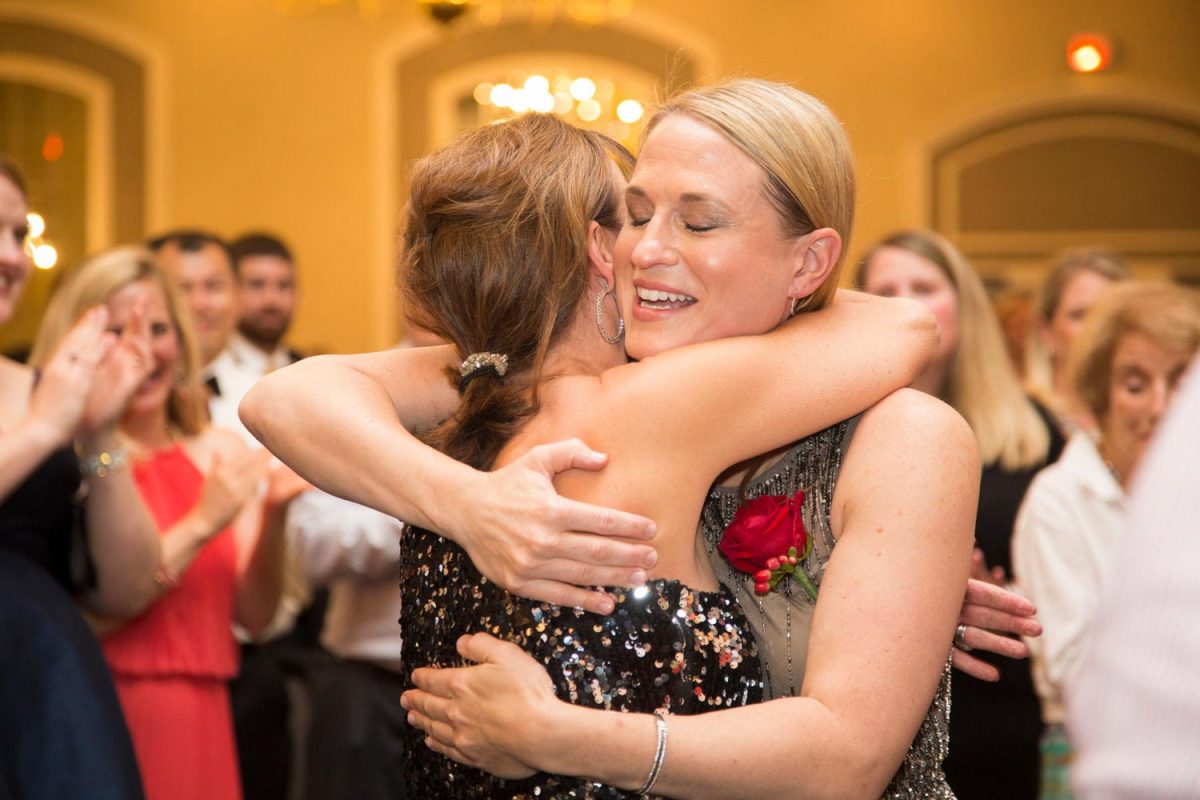 Corporate event photo of two women hugging