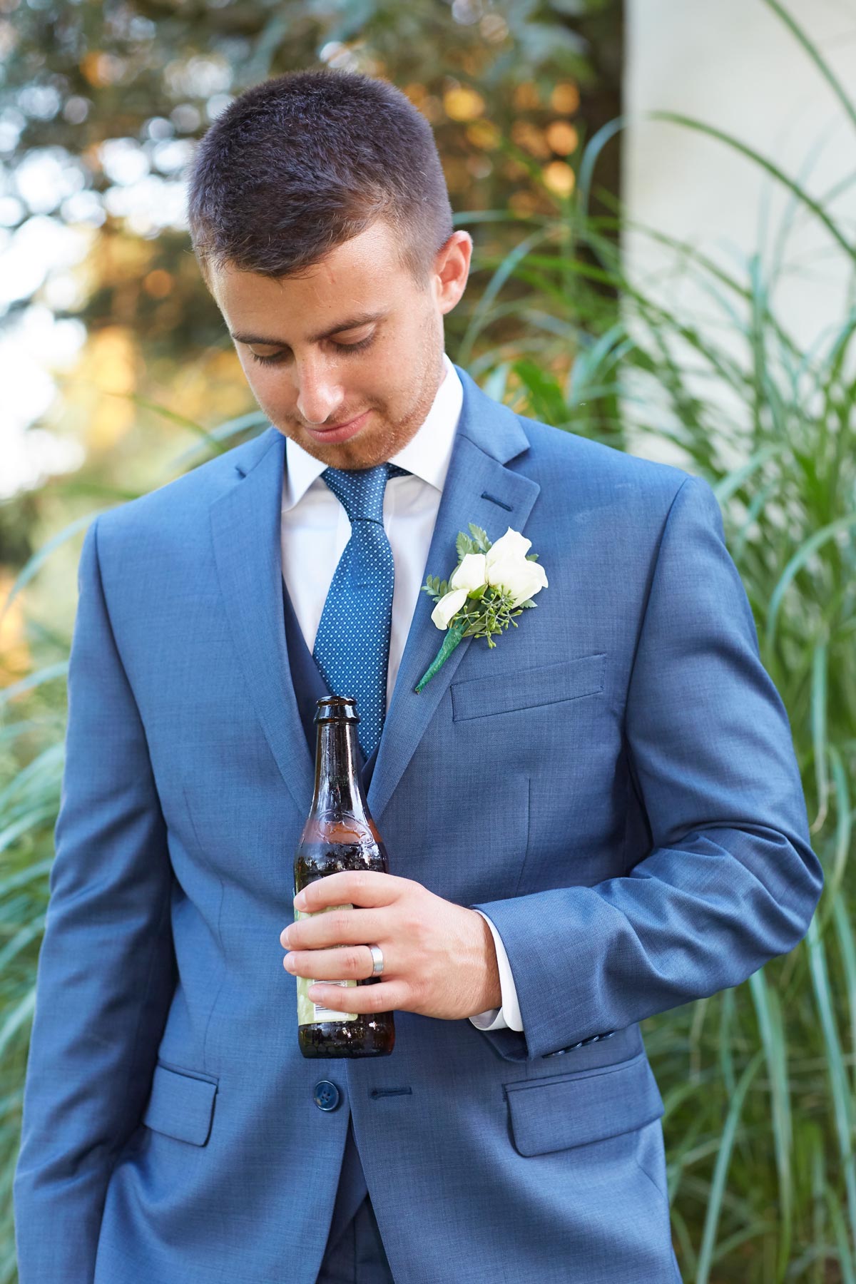Editorial lifestyle shot of a man in a blue suit with a boutonniere